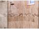 Detailed shower showcasing custom stone-patterned tile work and a modern shower head fixture at 22912 N San Ramon Ct, Sun City West, AZ 85375