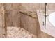 Spa-like shower features elegant pebble floor, granite bench, and glass enclosure at 22912 N San Ramon Ct, Sun City West, AZ 85375