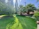 Lush backyard featuring artificial turf, mature landscaping, and shade trees at 2533 E Flower St, Phoenix, AZ 85016