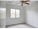 Bedroom with a ceiling fan, plush carpet, and a window, creating a comfortable and inviting atmosphere at 2533 E Flower St, Phoenix, AZ 85016