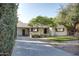 Inviting exterior view featuring a well-maintained lawn, mature trees, and a covered parking area at 2533 E Flower St, Phoenix, AZ 85016