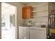 Functional laundry room equipped with a washer, dryer, and overhead storage shelves for convenience at 2533 E Flower St, Phoenix, AZ 85016