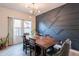Dining area with modern lighting, wood dining table, dark accent wall and stylish decor at 2939 W Sunshine Butte Dr, San Tan Valley, AZ 85144