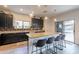 Modern kitchen featuring dark cabinets, granite countertops, stainless steel appliances, and a kitchen island at 2939 W Sunshine Butte Dr, San Tan Valley, AZ 85144