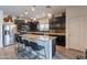 Modern kitchen with dark cabinets, stainless steel appliances, a tile backsplash, and a granite-topped island at 2939 W Sunshine Butte Dr, San Tan Valley, AZ 85144
