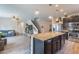 Open concept kitchen with island seating, dark cabinets, stainless appliances, and an open view to the living room at 2939 W Sunshine Butte Dr, San Tan Valley, AZ 85144