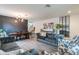 Open-plan living area with stylish decor, wood flooring, staircase, and abundant natural light at 2939 W Sunshine Butte Dr, San Tan Valley, AZ 85144