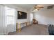 A spacious spare room provides two windows, ceiling fan, desk, television, and a chair at 2939 W Sunshine Butte Dr, San Tan Valley, AZ 85144