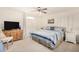 Bright bedroom features a bed with blue and white linens, white shutters, and a wooden TV cabinet at 3150 N 150Th Dr, Goodyear, AZ 85395