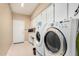 Spacious laundry room with modern front-load washer and dryer, ample cabinet space, and a utility sink at 3150 N 150Th Dr, Goodyear, AZ 85395