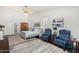 Bright main bedroom features a ceiling fan, sitting area, and a bed with blue and white patterned linens at 3150 N 150Th Dr, Goodyear, AZ 85395