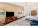 This comfortable main bedroom is bright and has a ceiling fan with a wooden TV cabinet at 3150 N 150Th Dr, Goodyear, AZ 85395