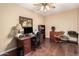 Well-lit home office with rich hardwood floors, wooden desk, and a comfortable executive chair at 3150 N 150Th Dr, Goodyear, AZ 85395