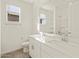 Bright bathroom featuring a double sink vanity, a toilet, and a window at 37325 W San Clemente St, Maricopa, AZ 85138