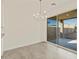 Open dining area with modern chandelier and sliding glass doors to the patio at 37325 W San Clemente St, Maricopa, AZ 85138