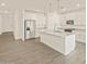 Modern kitchen with stainless steel appliances, a large island, and white cabinetry at 37325 W San Clemente St, Maricopa, AZ 85138