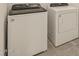 Modern laundry room with a new white Whirlpool washer and dryer at 37325 W San Clemente St, Maricopa, AZ 85138