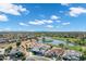 Picturesque aerial view of the neighborhood with a golf course and pond, surrounded by houses under a beautiful blue sky at 3842 E Alameda Ln, Gilbert, AZ 85298