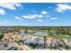 Enjoy picturesque living with an aerial view of houses and a golf course community surrounding a pond on a sunny day at 3842 E Alameda Ln, Gilbert, AZ 85298
