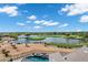 Scenic aerial view highlighting the golf course, water feature, and a luxurious pool and spa area of the property at 3842 E Alameda Ln, Gilbert, AZ 85298