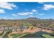Wide aerial shot of the community, featuring golf courses, a tranquil lake, and picturesque mountain views in the distance at 3842 E Alameda Ln, Gilbert, AZ 85298