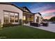 Serene backyard featuring a covered patio, green turf, pool, and modern outdoor furniture at 3842 E Alameda Ln, Gilbert, AZ 85298