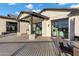 Covered patio with an outdoor kitchen, dining, and entertainment area, plus a grassy backyard at 3842 E Alameda Ln, Gilbert, AZ 85298