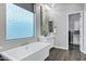 Bright bathroom showcasing a soaking tub beneath a decorative window and a vanity with luxury mirror at 3842 E Alameda Ln, Gilbert, AZ 85298