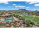 Community aerial view of pool, seating area and golf course against a mountain backdrop at 3842 E Alameda Ln, Gilbert, AZ 85298
