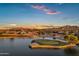 Sunset aerial view featuring golf course, lake, and mountain views at 3842 E Alameda Ln, Gilbert, AZ 85298