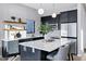 Well-lit kitchen featuring an island with seating, dark cabinets, stainless steel appliances, and modern pendant lighting at 3842 E Alameda Ln, Gilbert, AZ 85298