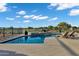 Backyard pool with tiled water feature, stone surround, lounge chairs, and views of a lake at 3842 E Alameda Ln, Gilbert, AZ 85298