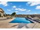 A refreshing swimming pool with sun loungers on the patio, set against a lovely blue sky at 3842 E Alameda Ln, Gilbert, AZ 85298