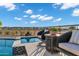 Inviting pool area with seating, beautiful tile work, and desert landscaping under a sunny, blue sky at 3842 E Alameda Ln, Gilbert, AZ 85298