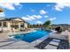 Sparkling pool with black pebble features surrounded by lounge chairs in a landscaped backyard oasis at 3842 E Alameda Ln, Gilbert, AZ 85298