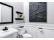 Stylish powder room with elegant black and white decor, wainscoting, and modern fixtures at 3842 E Alameda Ln, Gilbert, AZ 85298