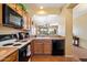 Well-lit kitchen featuring standard appliances, functional cabinets, and view to living area at 40055 N High Noon Way, Anthem, AZ 85086