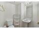 Cozy half bath featuring a pedestal sink, tiled floors and a decorative mirror at 4446 E Woodridge Dr, Phoenix, AZ 85032