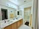 Bathroom features double sinks, wood cabinets, a large mirror and a shower at 4446 E Woodridge Dr, Phoenix, AZ 85032
