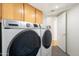 Convenient laundry room with modern appliances and ample cabinet space for storage and organization at 4446 E Woodridge Dr, Phoenix, AZ 85032