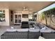 Spacious covered patio featuring comfortable seating, a ceiling fan, and an outdoor television for entertainment at 4446 E Woodridge Dr, Phoenix, AZ 85032