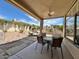 Inviting covered patio featuring a ceiling fan, dining table set, and views of the landscaped backyard at 4446 E Woodridge Dr, Phoenix, AZ 85032