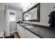 Bright bathroom featuring double sink vanity with grey countertops, and a framed mirror with modern lighting at 4611 E Monterosa St, Phoenix, AZ 85018