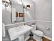 Chic powder room featuring a pedestal sink, chrome fixtures, and classic decorative elements at 4611 E Monterosa St, Phoenix, AZ 85018