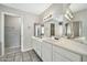 Bathroom with double sink vanity, tiled floors, and large mirrors at 5029 N 86Th Dr, Glendale, AZ 85305