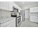 A well lit kitchen features white cabinets, granite countertops, and stainless steel appliances at 5029 N 86Th Dr, Glendale, AZ 85305