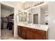 Bright bathroom featuring a double vanity, a large mirror, and a walk-in closet for ample storage space at 5436 W Chisum Trl, Phoenix, AZ 85083
