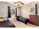 Comfortable bedroom with two beds, dresser, ceiling fan, and a window for natural light at 5436 W Chisum Trl, Phoenix, AZ 85083