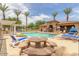 A community pool with clear blue water, lounge chairs, and picnic tables at 5436 W Chisum Trl, Phoenix, AZ 85083