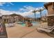 View of community pool surrounded by lounge chairs, tables, and a pergola at 5436 W Chisum Trl, Phoenix, AZ 85083